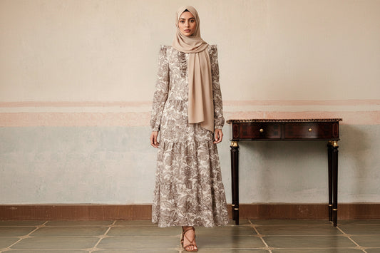 Woman wearing a long floral dress in an elegant indoor setting