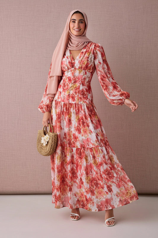 Woman wearing a floral dress with long sleeves against a beige background