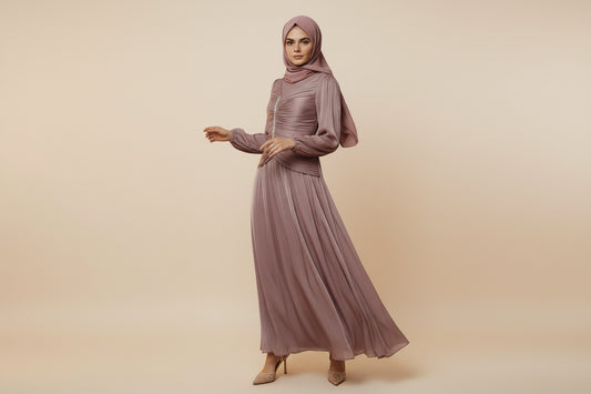 Woman wearing a long, flowing dress with a textured wall background